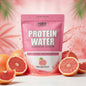 Pink and white protein water package with MAHI branding on a shelf.